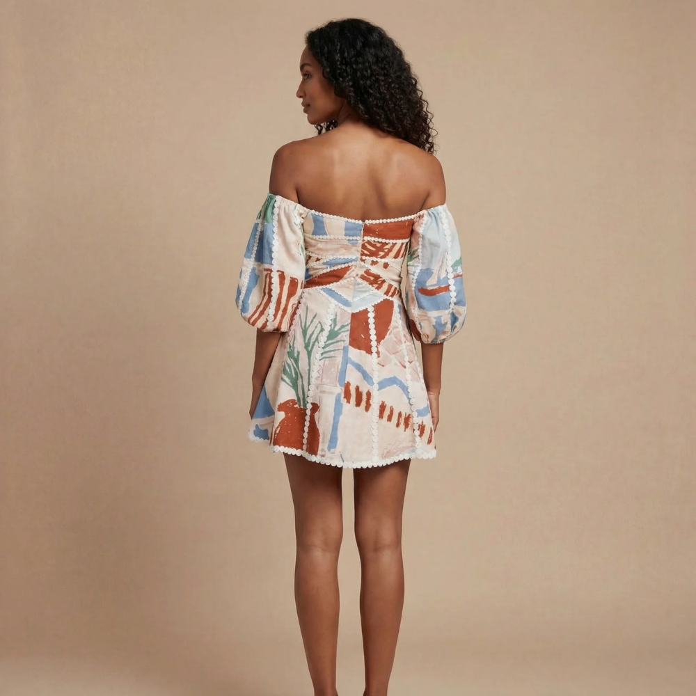 Back view of women's off-shoulder printed mini dress showing back zipper closure with pearl bead detailing