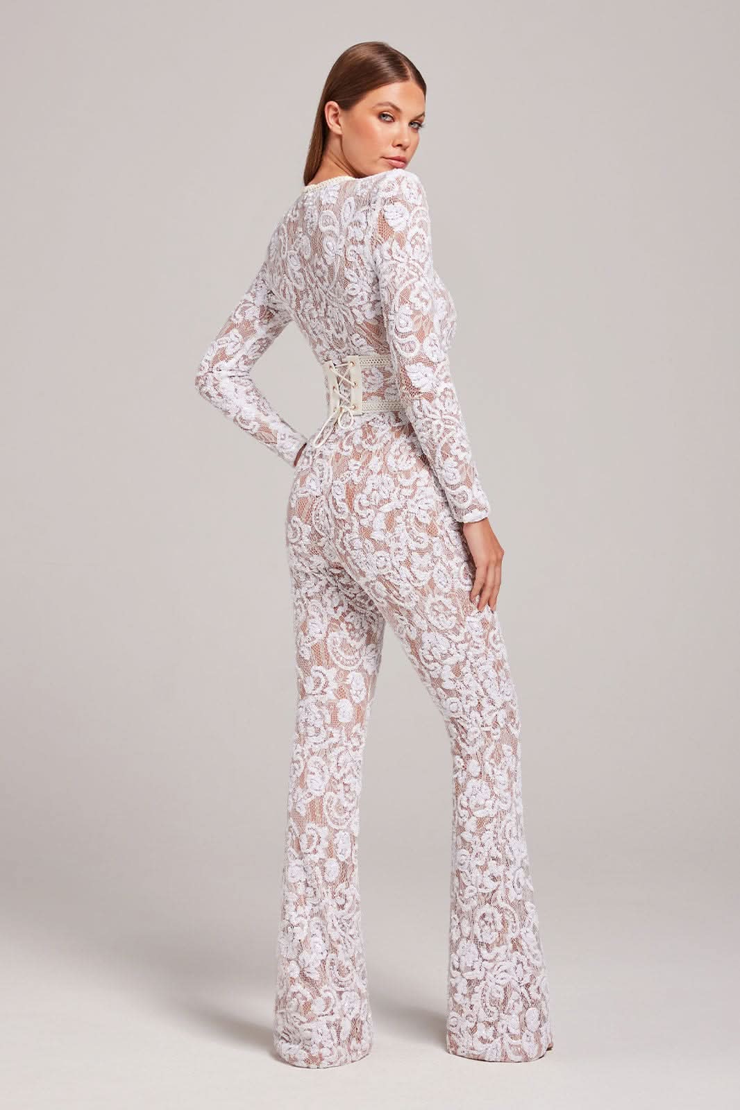 Side back view of white lace long sleeve jumpsuit with flared legs