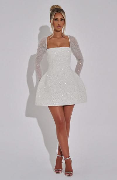 Women white sequin mini dress with square neckline and sheer long sleeves, front view