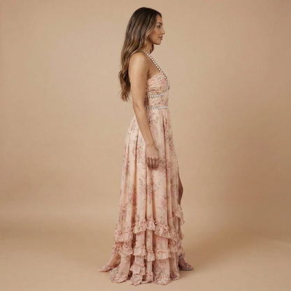 Side view of blush pink floral halter dress with layered ruffles and slit