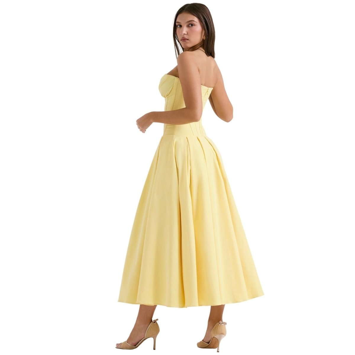 Woman wearing a yellow strapless dress on a white background