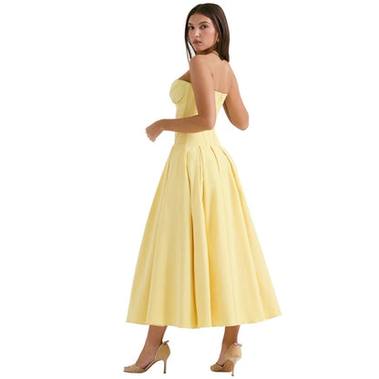 Woman wearing a yellow strapless dress on a white background