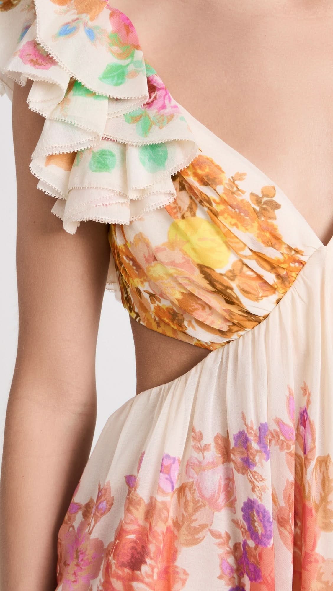 Close-up of ruffled cap sleeve with scalloped edging on multicolor floral print dress