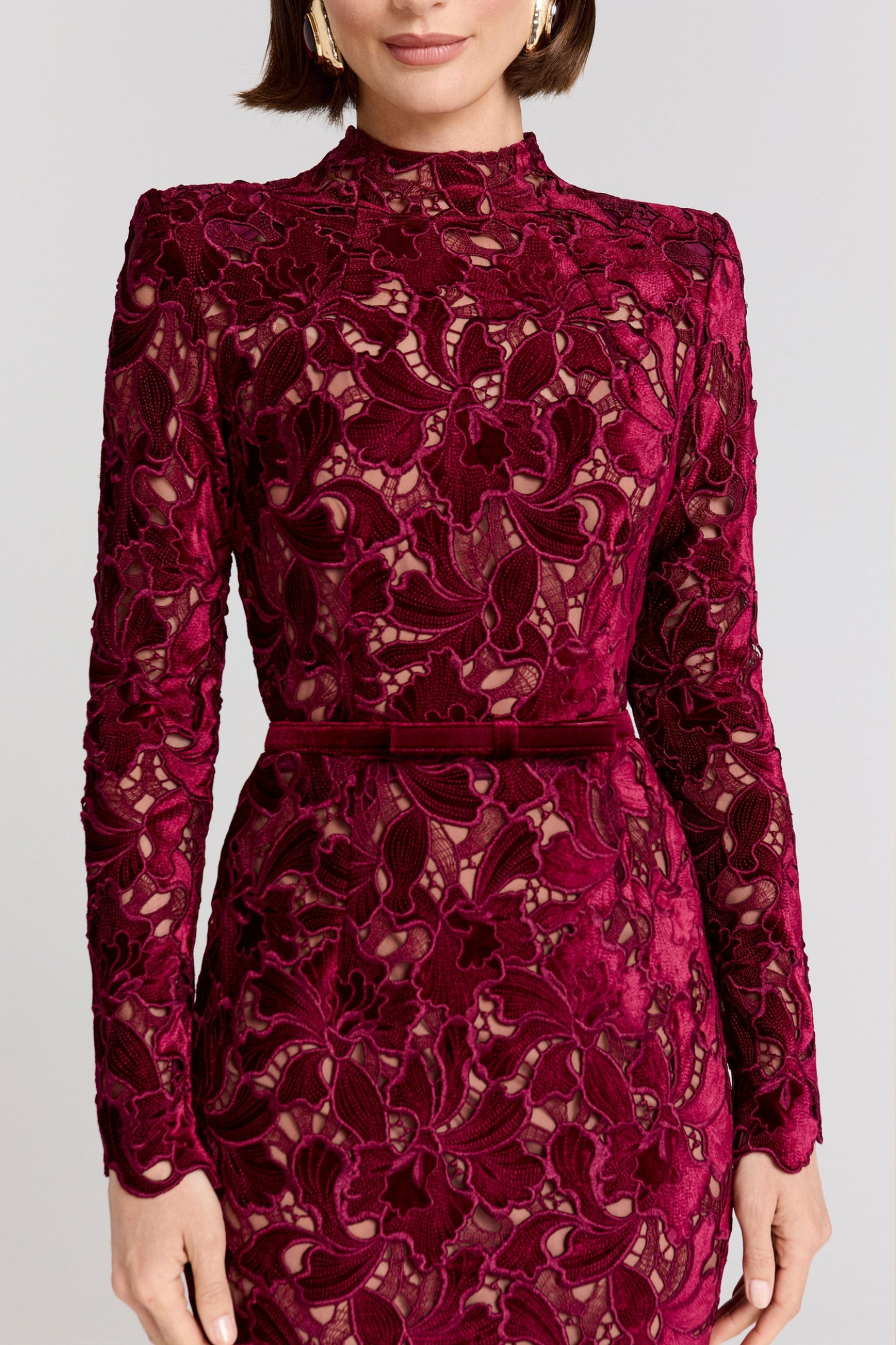 Close-up of burgundy lace dress neckline and floral lace pattern with cutouts