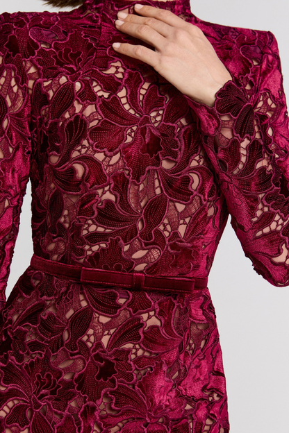 Close-up of burgundy lace dress waist belt and floral lace texture detail