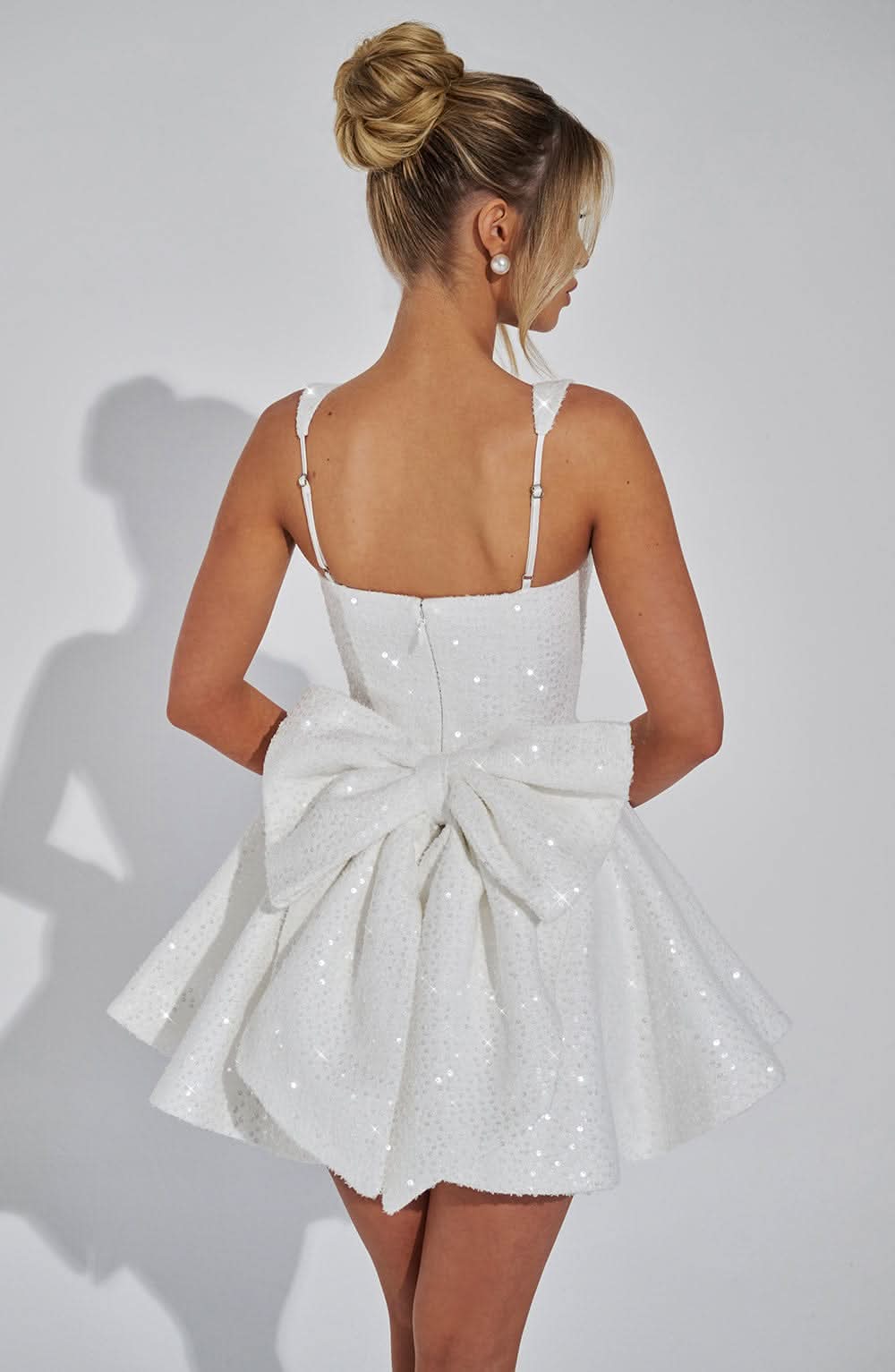 Women white sequin mini dress back angle featuring bow and rear zipper closure