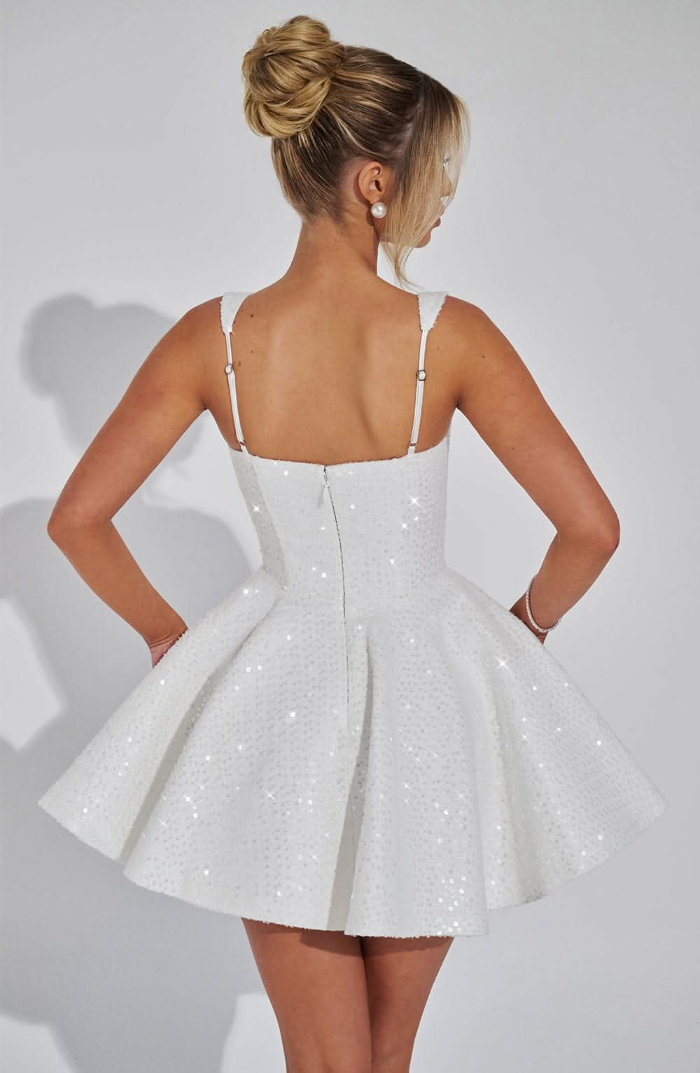 Women white sequin mini dress back view showing structured bow accent and fit