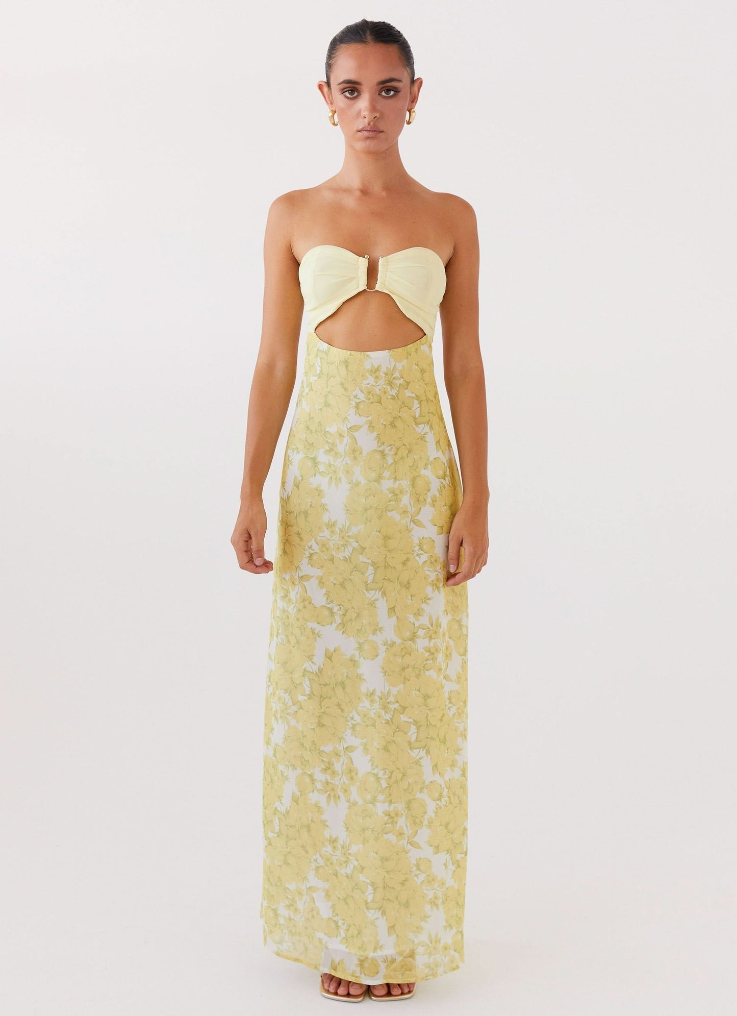 Front view of women's yellow floral maxi dress with ruched bodice and underbust cutout
