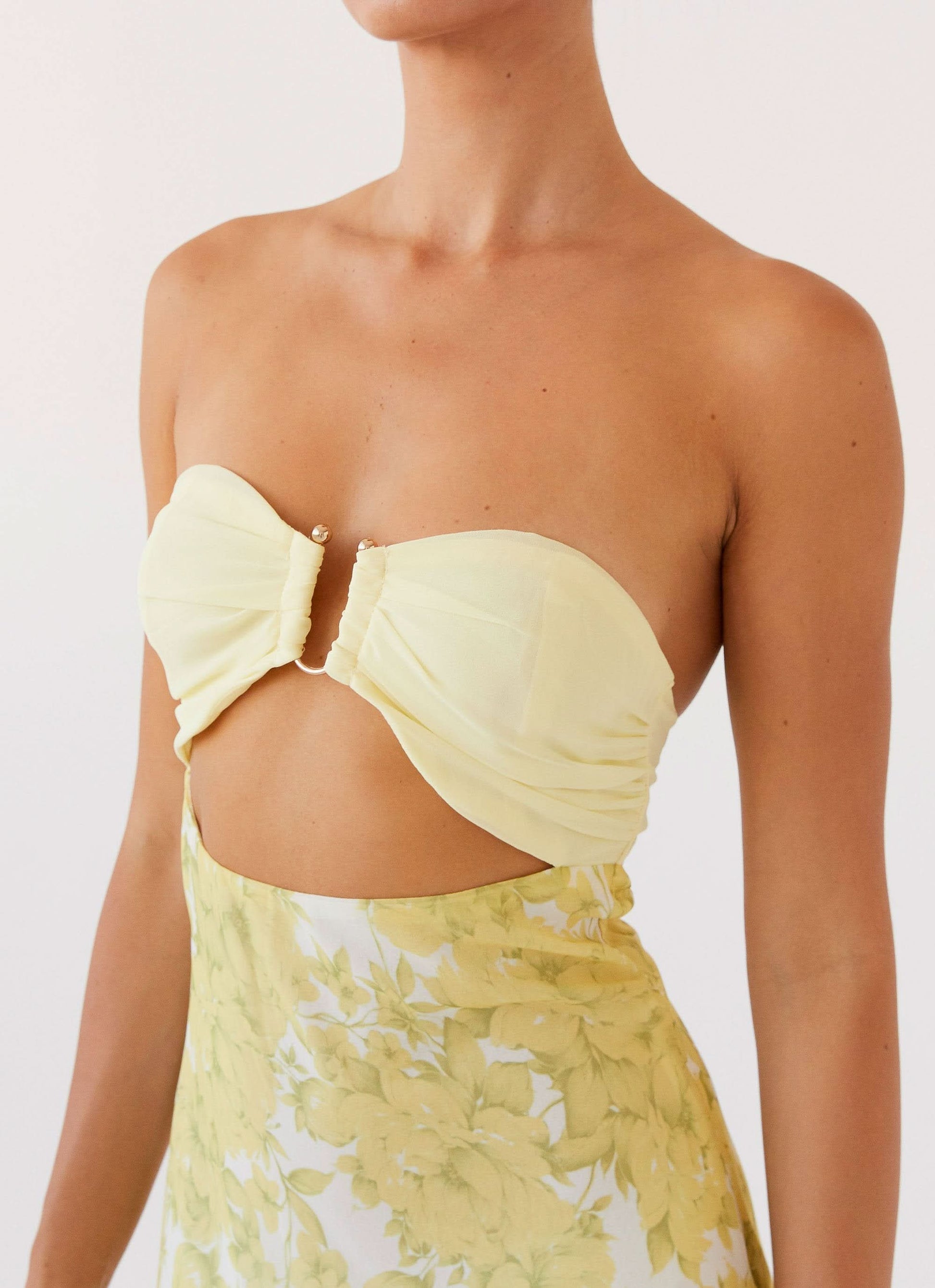 Close-up of sweetheart neckline with ruched detail and center hardware on yellow dress