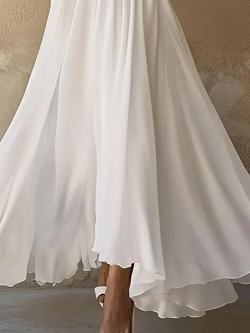 White maxi dress layered hem and flowing skirt construction close-up detail
