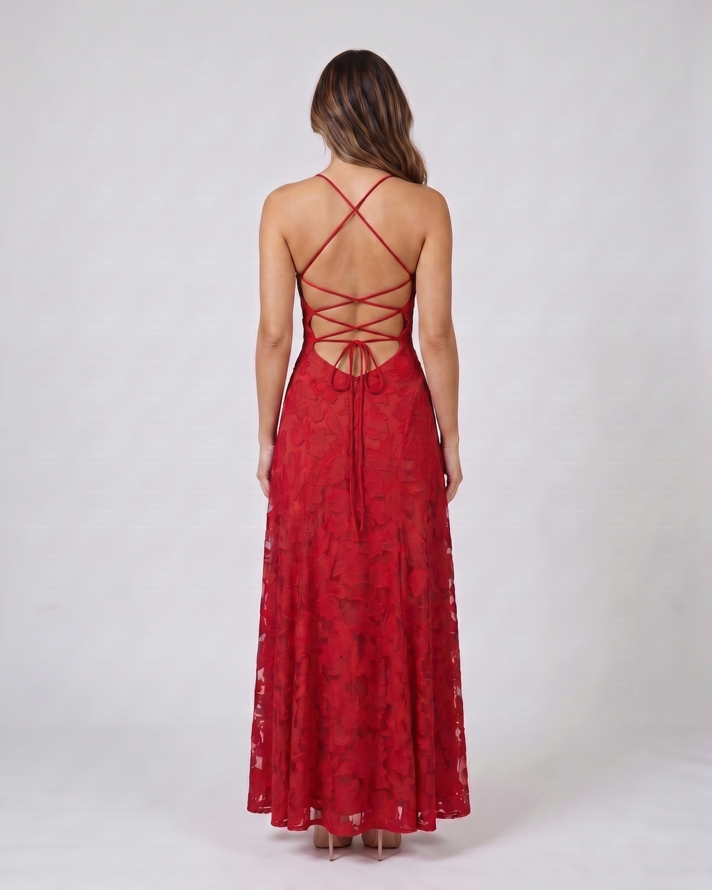 Back view of red floral lace square neck maxi dress showing open back with criss-cross spaghetti straps and tie closure