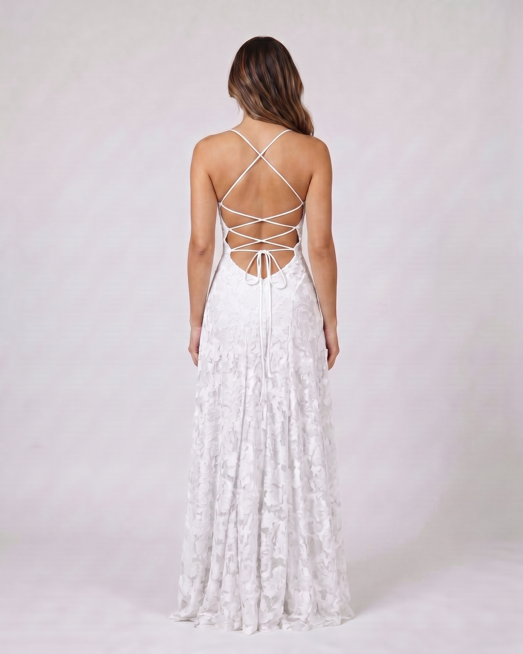 Back view of white floral lace square neck maxi dress showing open back with criss-cross spaghetti straps and tie closure