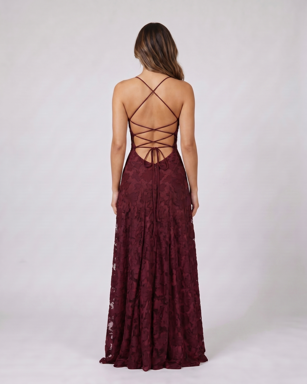 Back view of burgundy floral lace square neck maxi dress showing open back with criss-cross spaghetti straps and tie closure