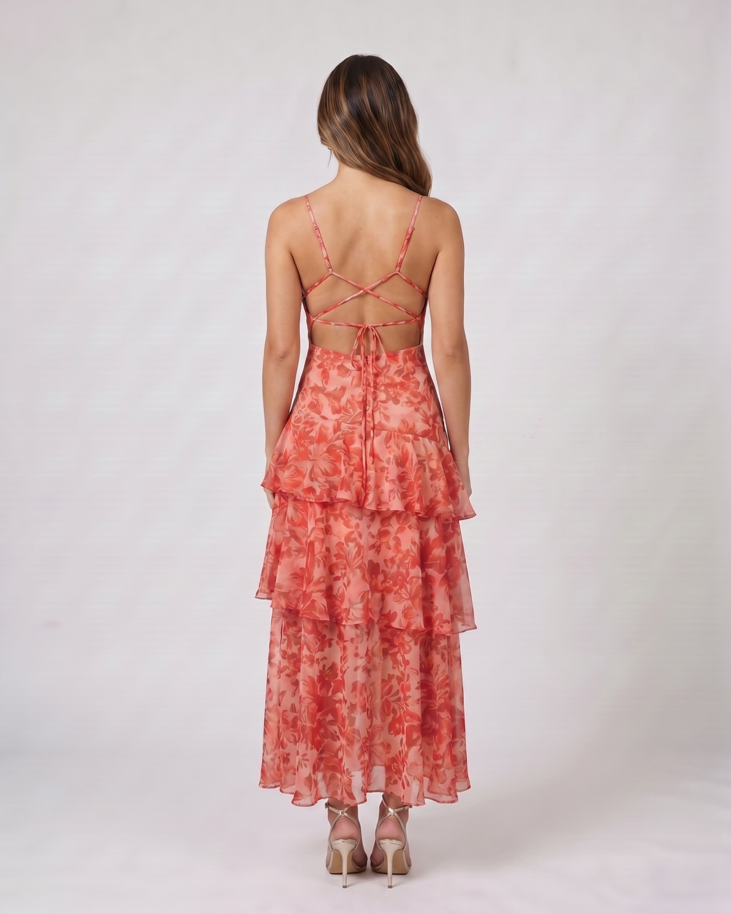 Back view of red floral plunge neck tiered midi dress showing open back with cross-back straps and tie closure