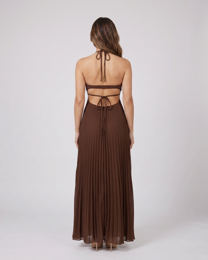 Back view of dark brown halter pleated with cutout maxi dress showing open back with horizontal mid-back strap and criss-cross tie straps at lower back