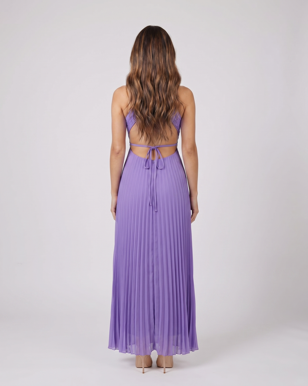 Back view of purple halter pleated with cutout maxi dress showing open back with horizontal mid-back strap and criss-cross tie straps at lower back