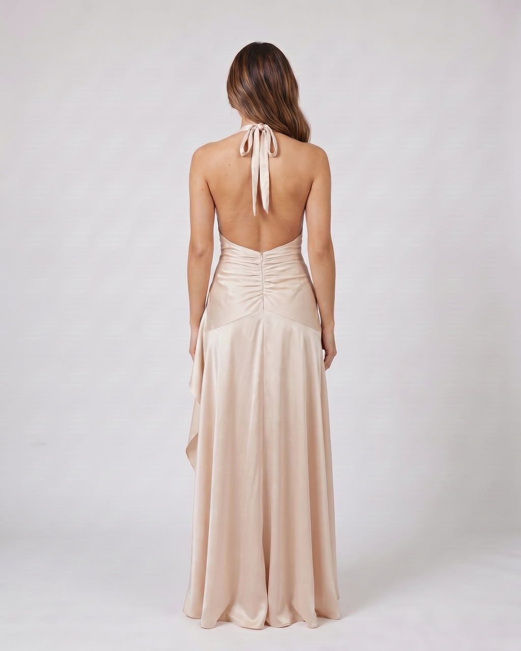 Back view of champagne halter plunge neck ruffle maxi dress showing open back with halter tie-back closure