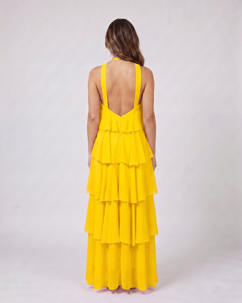 Back view of yellow halter rosette tiered maxi dress showing deep V-open back with wide halter straps