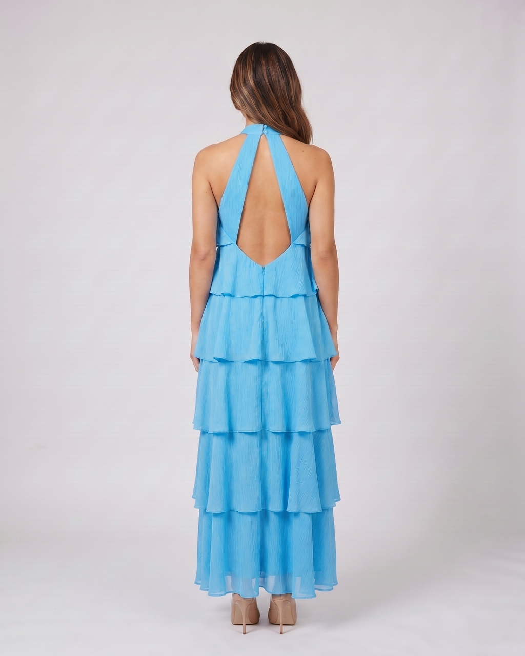 Back view of blue halter rosette tiered maxi dress showing deep V-open back with wide halter straps