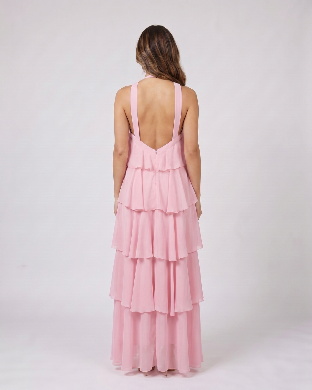 Back view of pink halter rosette tiered maxi dress showing deep V-open back with wide halter straps