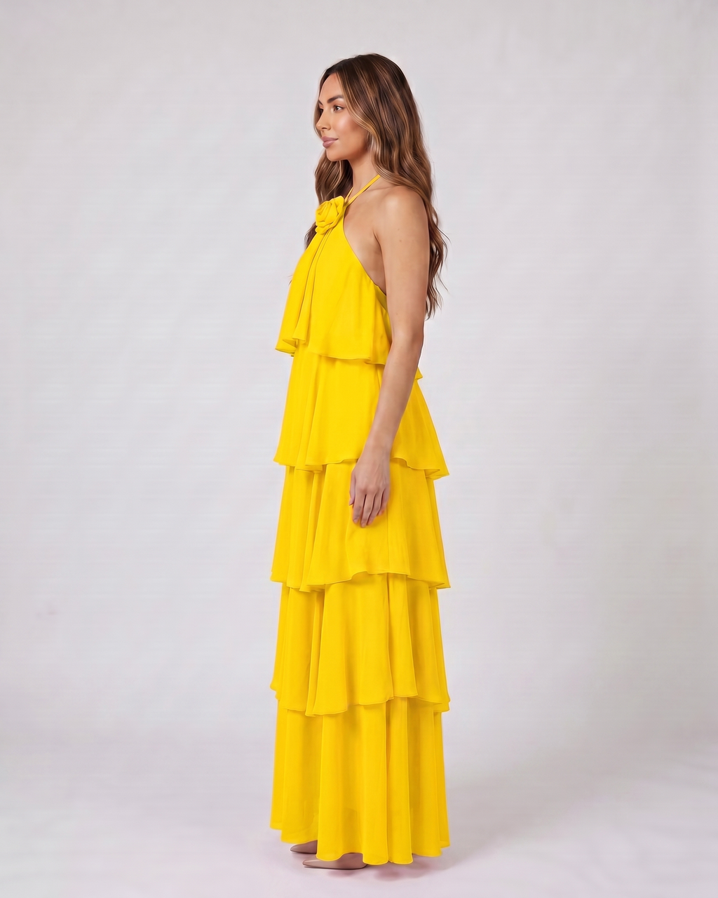 Side view of yellow halter rosette tiered maxi dress