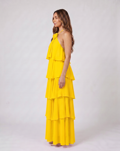Side view of yellow halter rosette tiered maxi dress