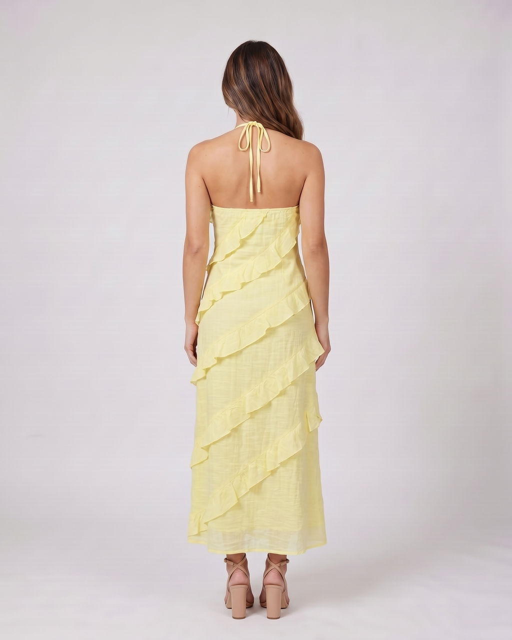 Back view of lemon halter v neck tiered ruffle maxi dress showing open back with halter tie closure