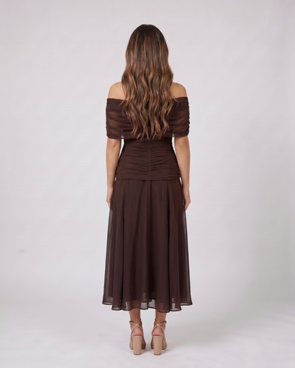 Back view of brown off shoulder ruched midi dress showing solid back with draped and ruched details
