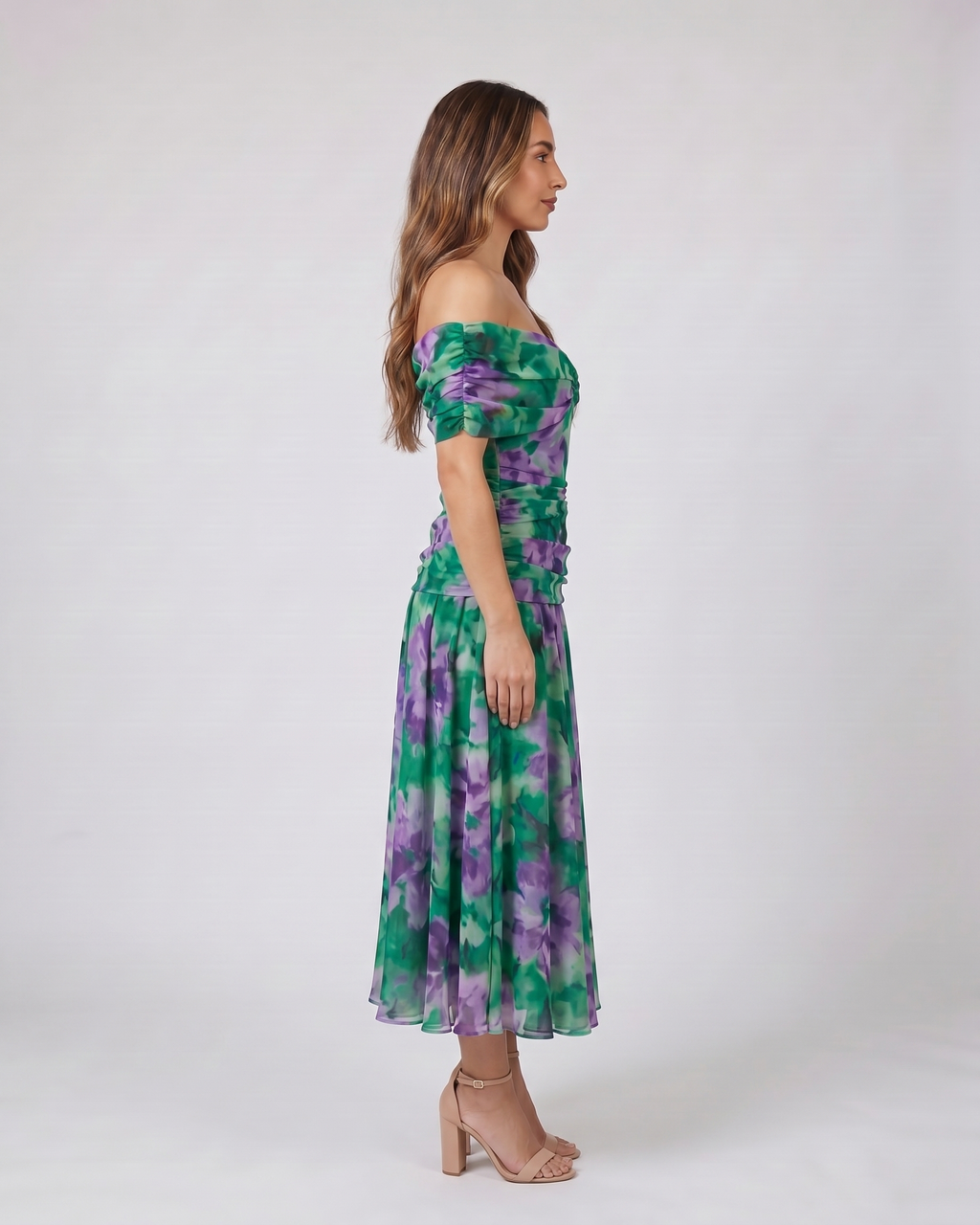Side view of green and purple off shoulder ruched midi dress