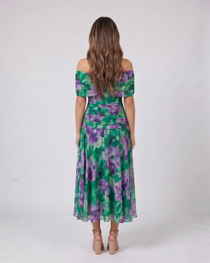 Back view of green and purple off shoulder ruched midi dress showing solid back with draped and ruched details