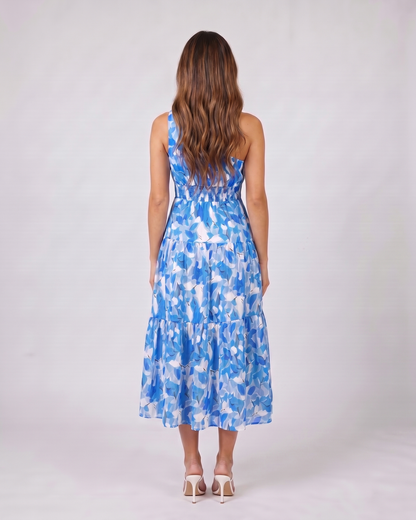 Back view of blue floral one shoulder floral tiered midi dress showing Solid back with shirred elasticated waist panel
