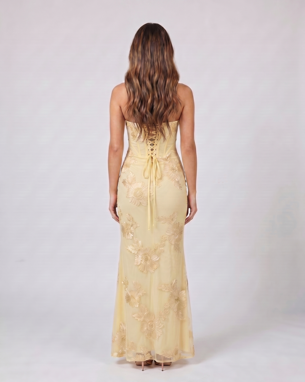 Back view of yellow prom sweetheart floral appliqué maxi dress showing lace-up corset back