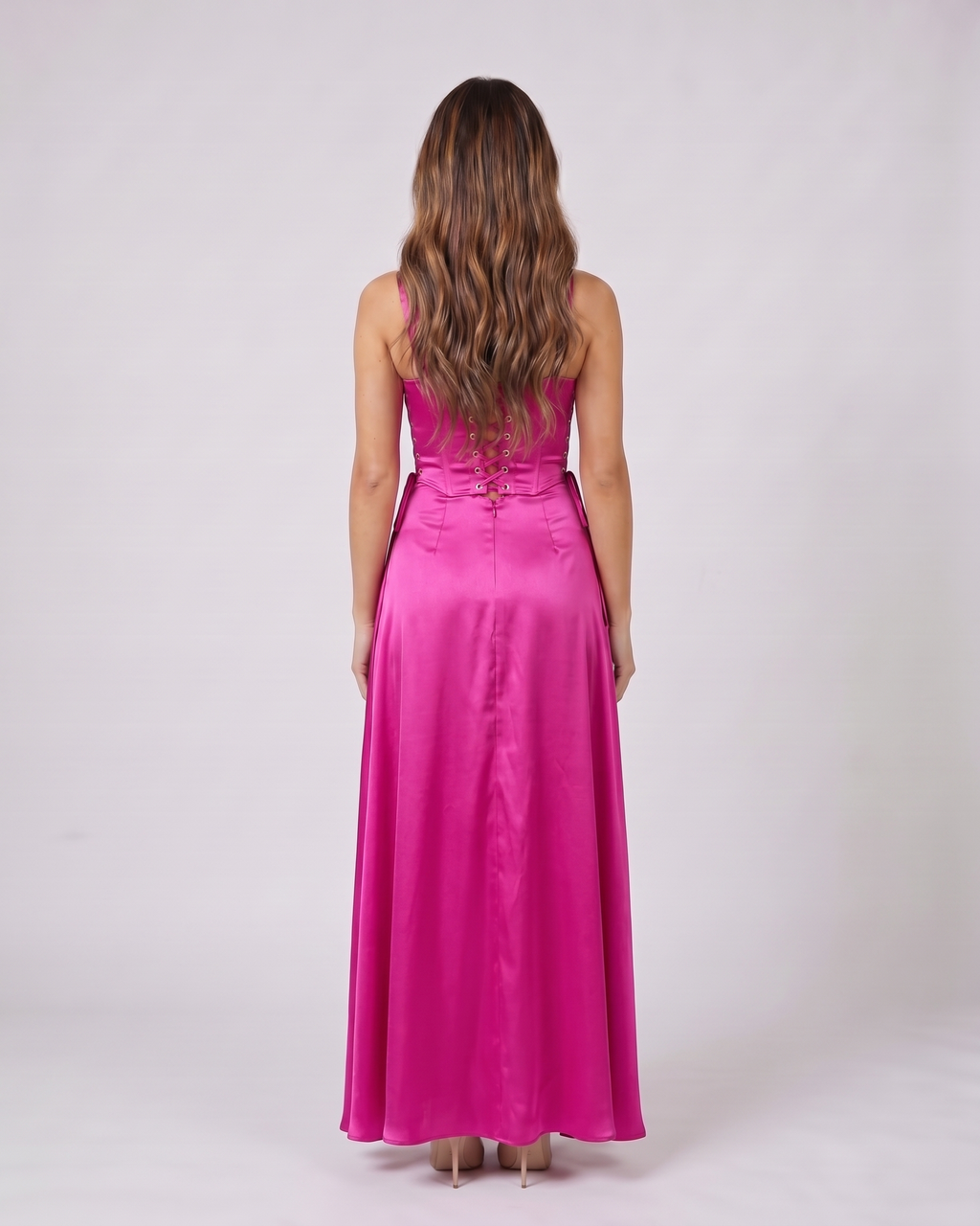 Back view of pink satin square neck seamed maxi dress showing lace-up corset back with metallic grommets