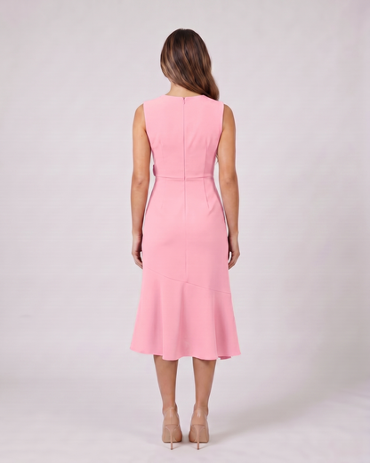 Back view of pink sleeveless asymmetric draped midi dress showing solid back with center back zipper closure