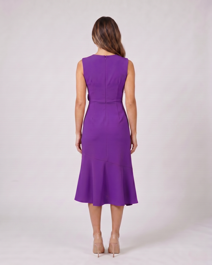 Back view of purple sleeveless asymmetric draped midi dress showing solid back with center back zipper closure