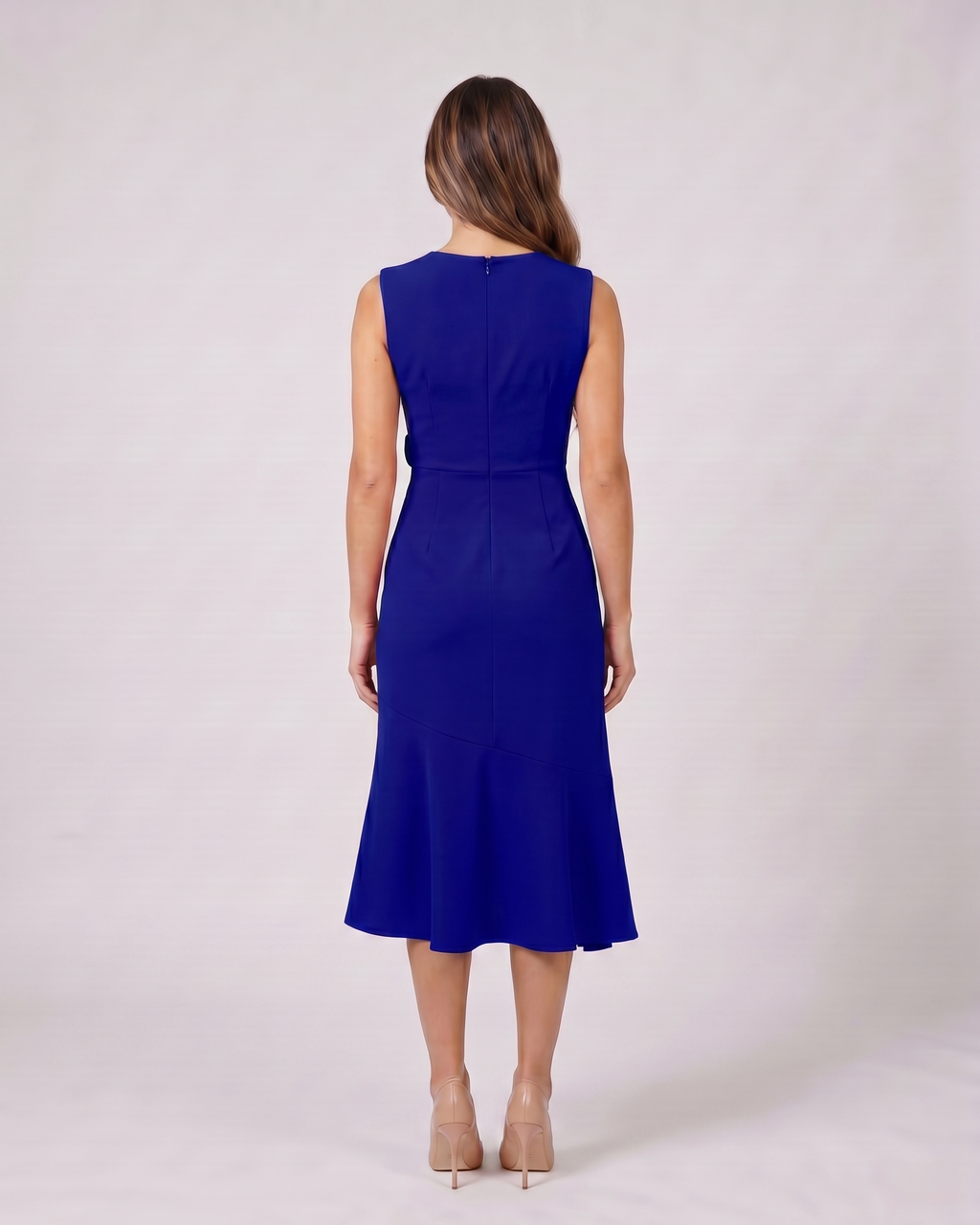 Back view of navy blue sleeveless asymmetric draped midi dress showing solid back with center back zipper closure