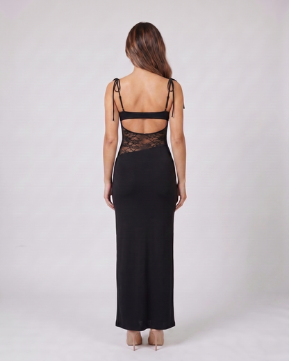Back view of black square neck lace panel maxi dress showing open-panel back with horizontal mid-back strap and integrated lace detail