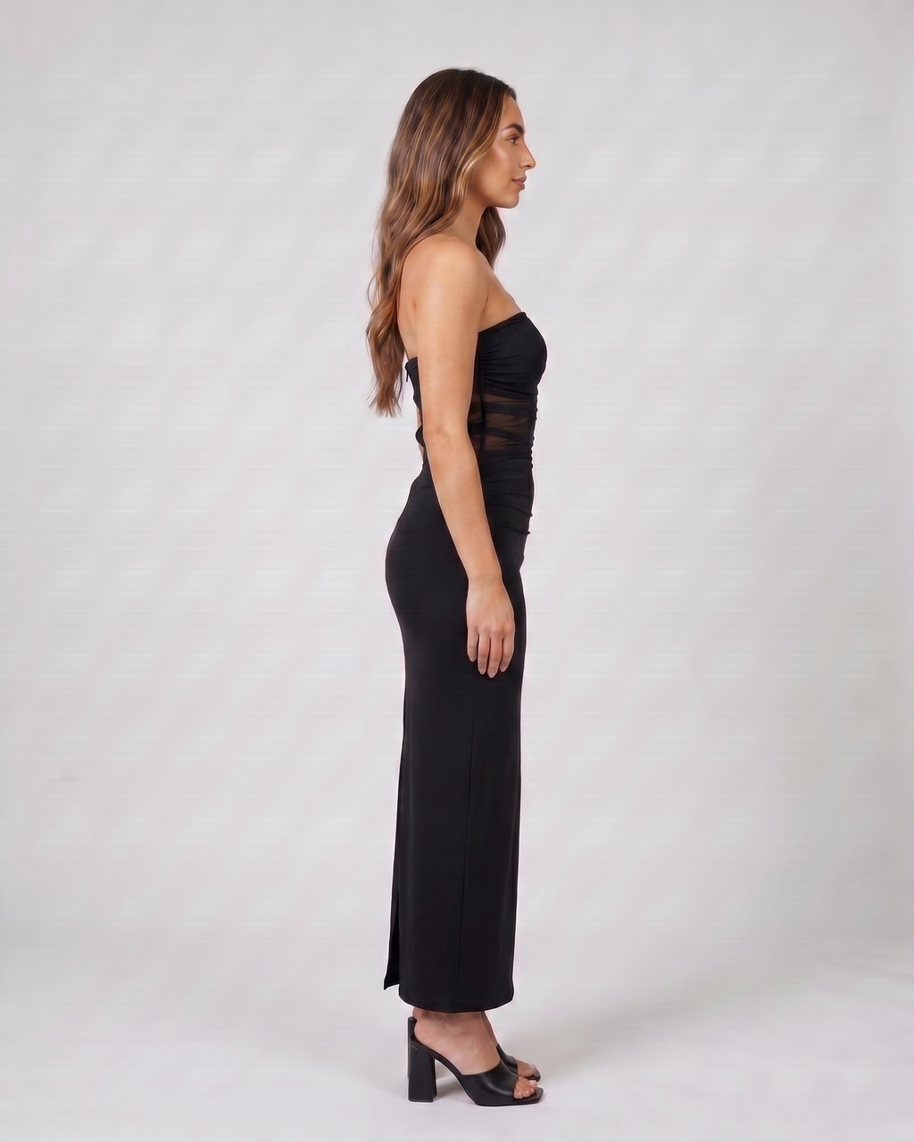 Side view of black strapless bodycon with scarf maxi dress