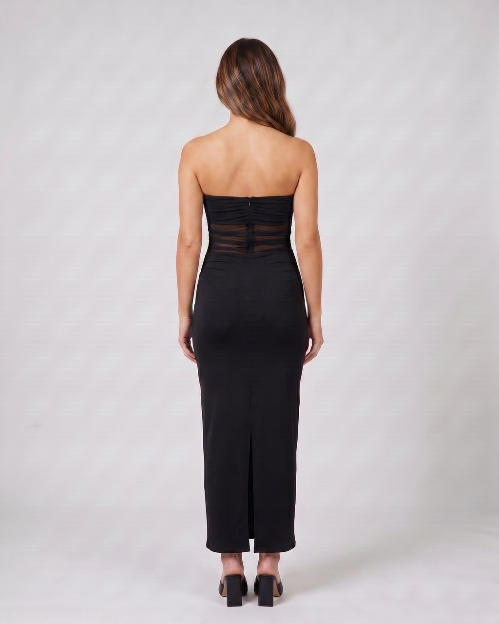 Back view of black strapless bodycon with scarf maxi dress showing solid back with concealed center back zipper and center back slit at hem