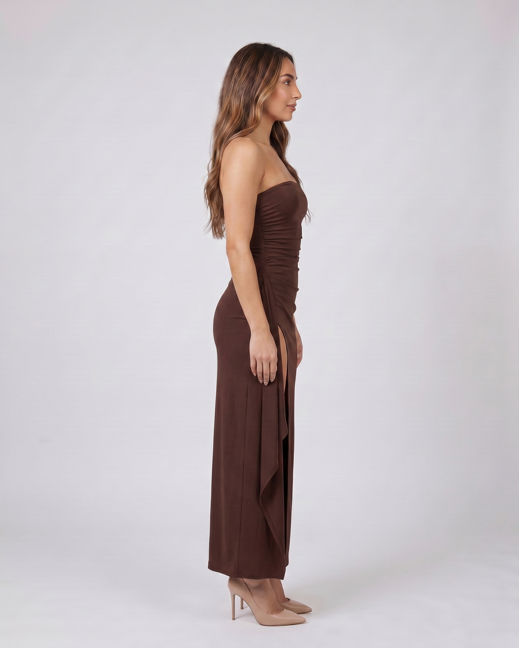 Side view of brown strapless ruched thigh split maxi dress