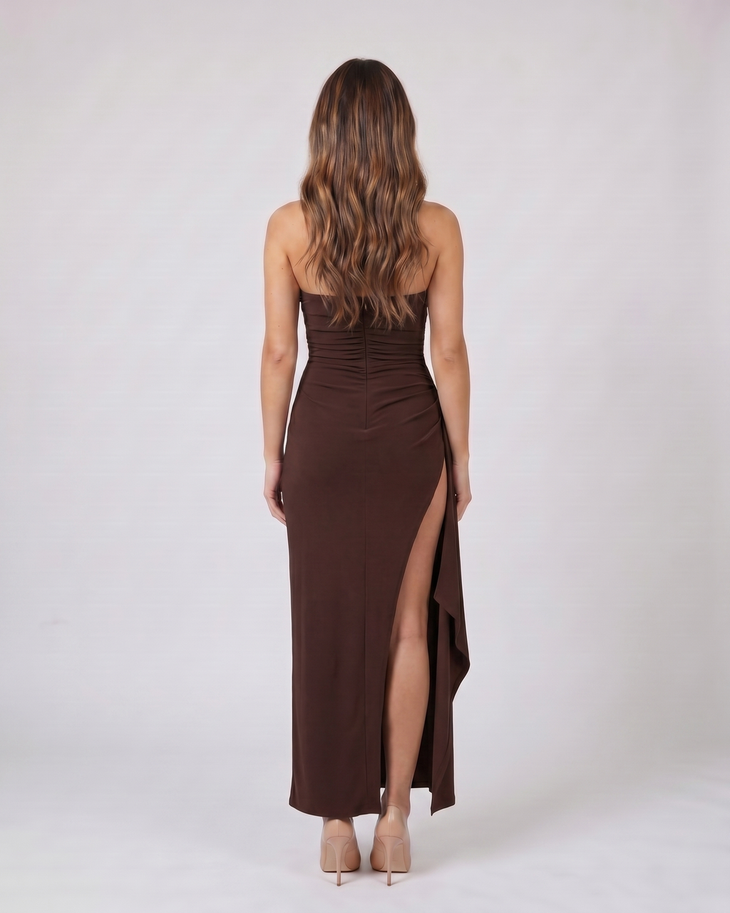 Back view of brown strapless ruched thigh split maxi dress showing solid back with center back zipper closure