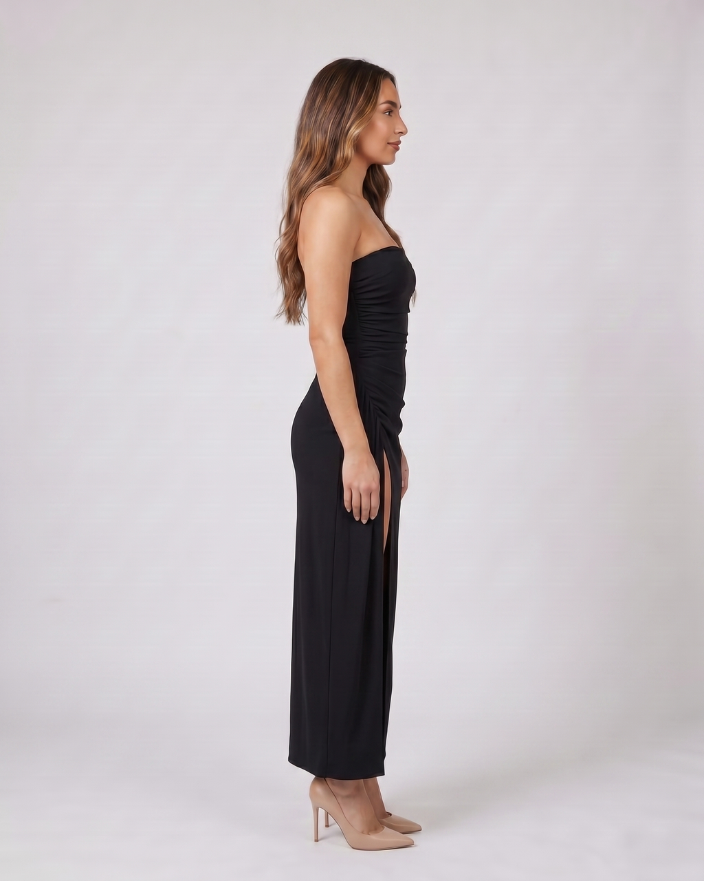 Side view of black strapless ruched thigh split maxi dress