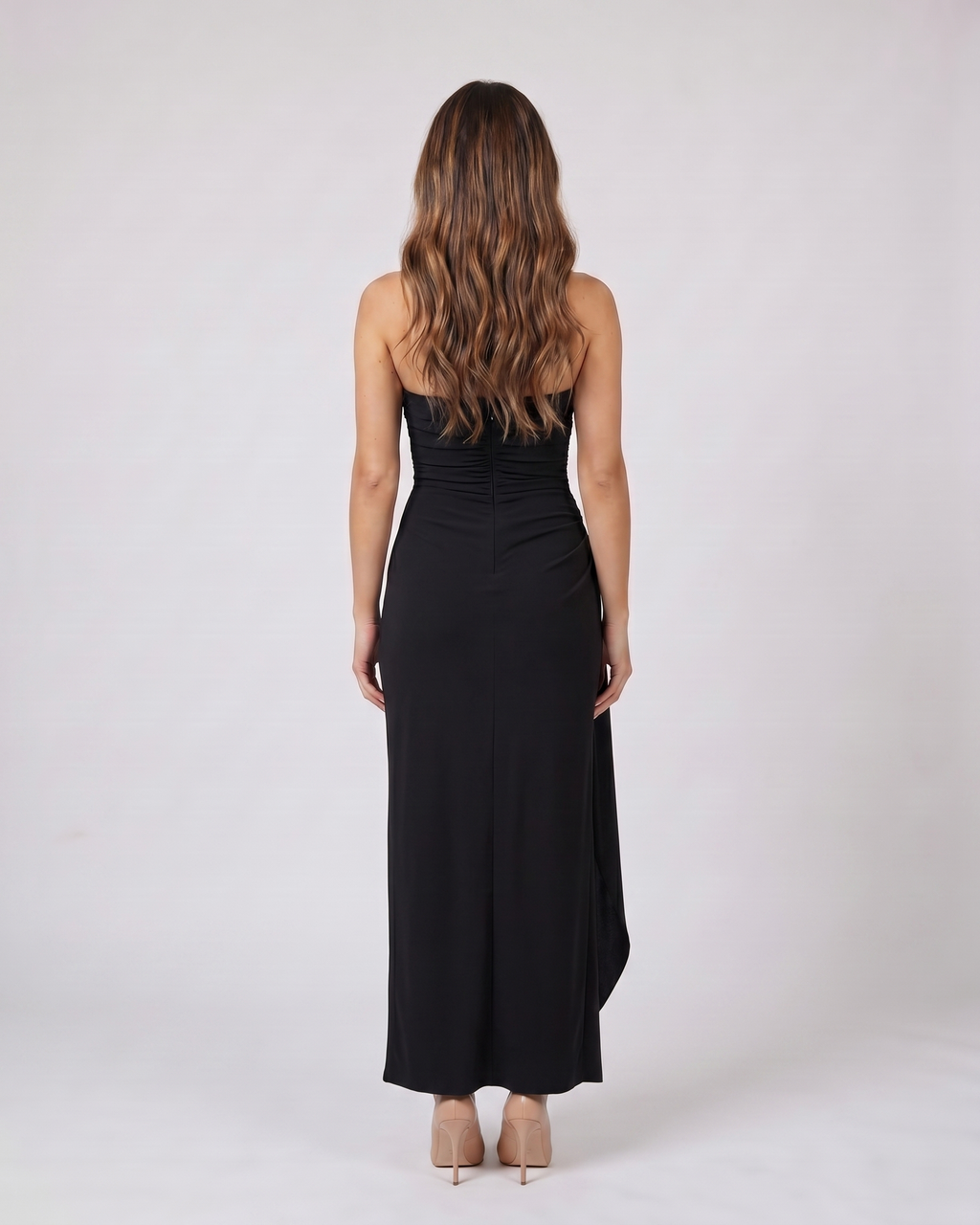 Back view of black strapless ruched thigh split maxi dress showing solid back with center back zipper closure