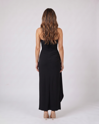 Back view of black strapless ruched thigh split maxi dress showing solid back with center back zipper closure