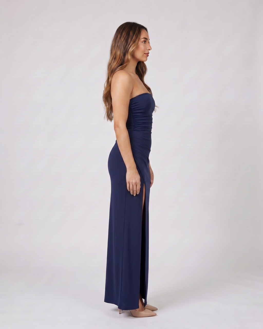 Side view of navy blue strapless ruched thigh split maxi dress