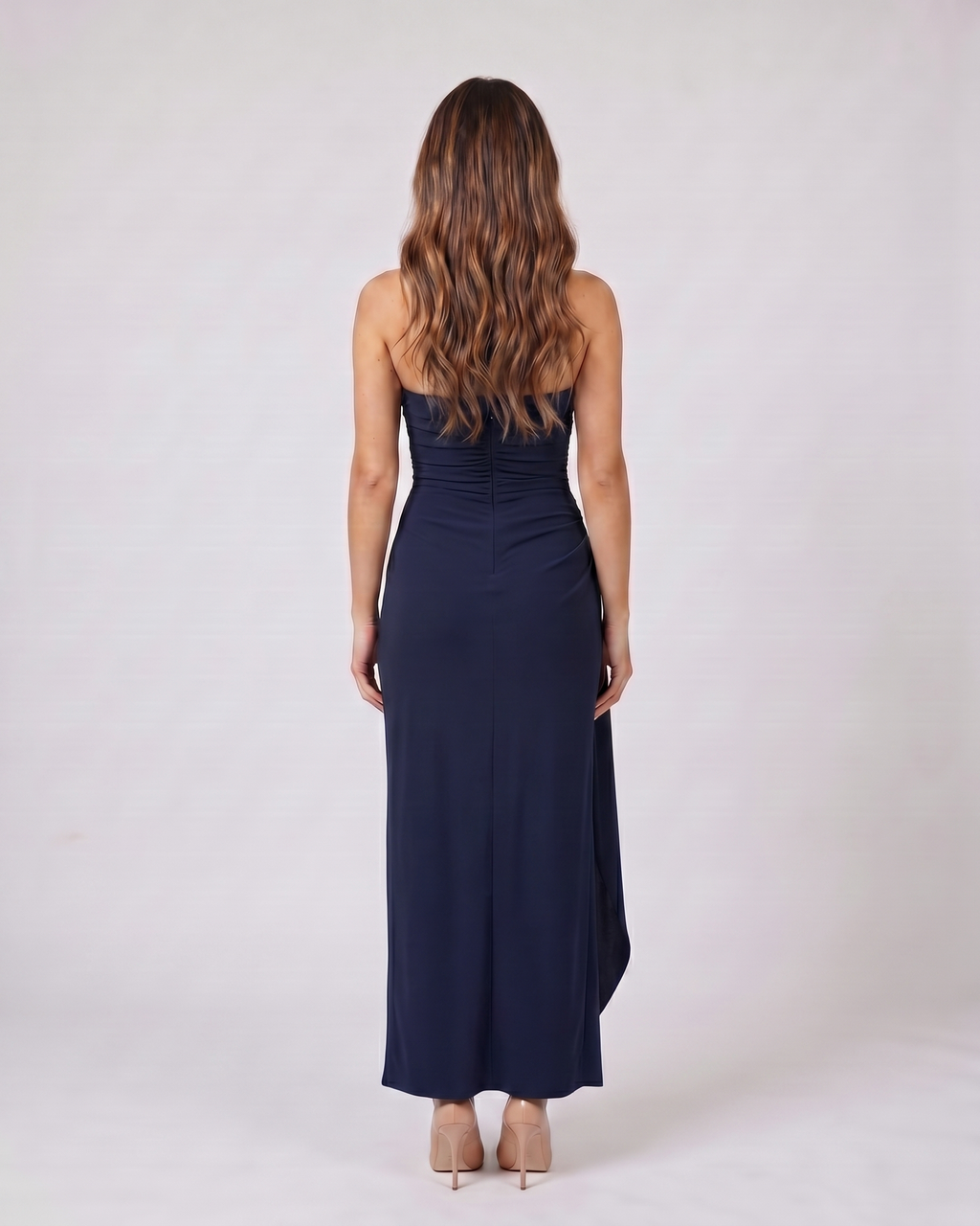 Back view of navy blue strapless ruched thigh split maxi dress showing solid back with center back zipper closure
