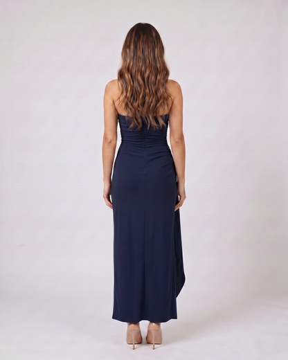 Back view of navy blue strapless ruched thigh split maxi dress showing solid back with center back zipper closure