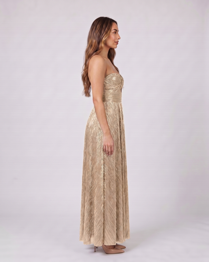 Side view of champagne strapless twist front keyhole maxi dress