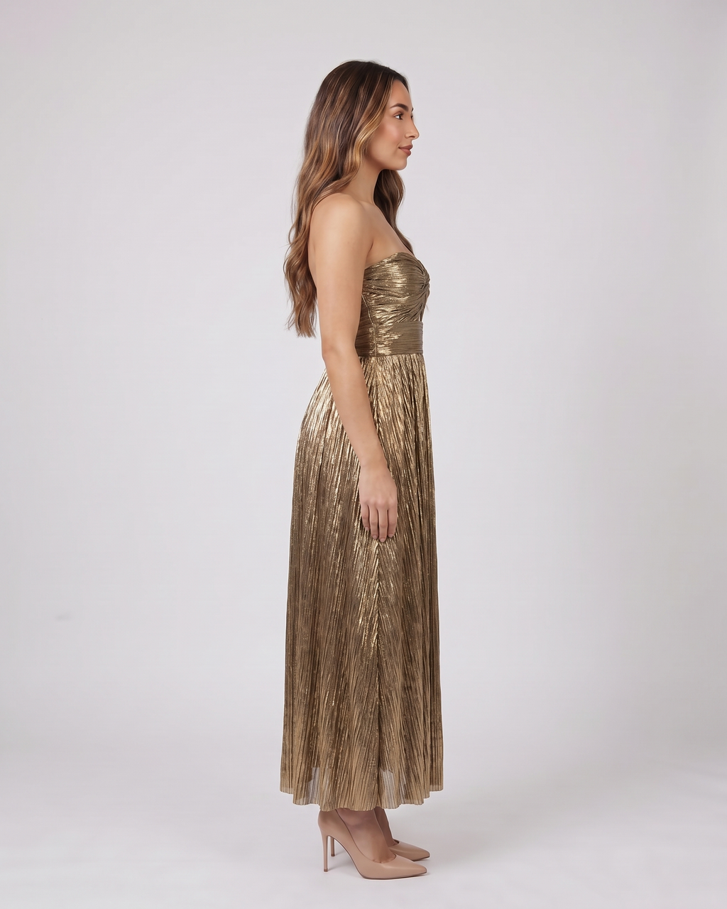 Side view of gold strapless twist front keyhole maxi dress