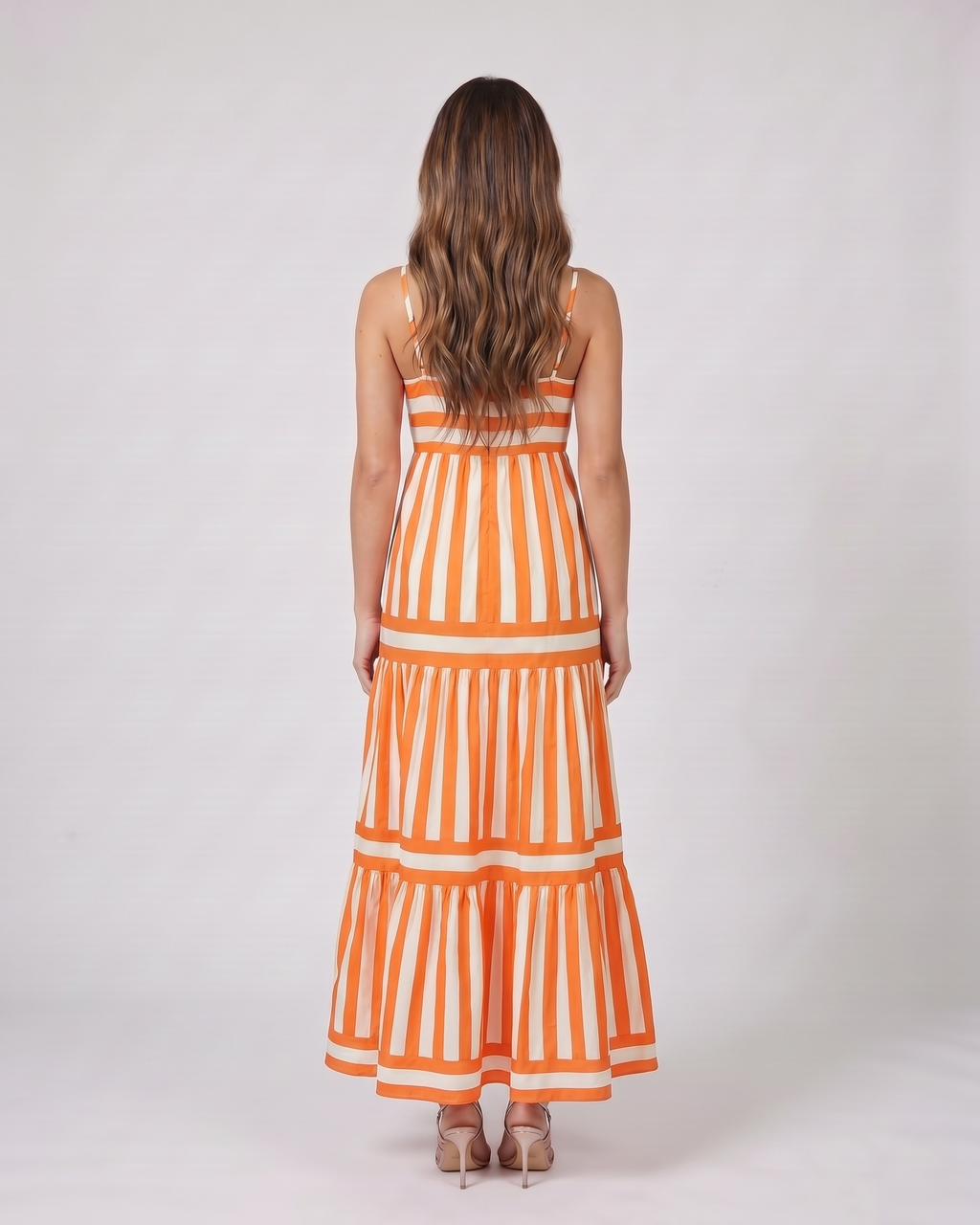 Back view of orange striped spaghetti strap maxi dress showing solid back with invisible zipper closure